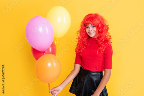 child smile with party balloon on yellow background