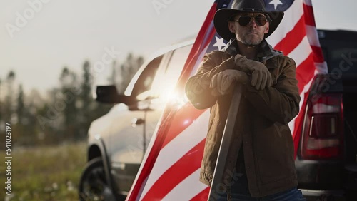 Caucasian American Patiot Cowboy Farmer Staying  in Front of His Pickup Truck and American National Flag photo