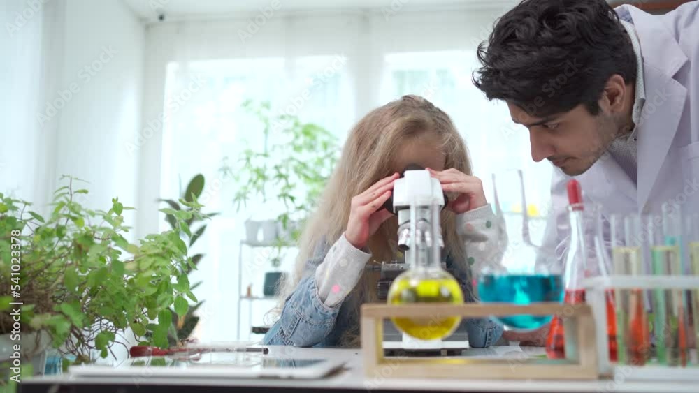 Little girl enjoy a science experiment with a professional scientist. Little girl enjoy a science experiment with a professional scientist.