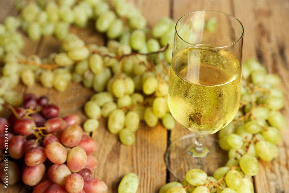 glass of wine with grapes on wooden table glass of wine with grapes on wooden table