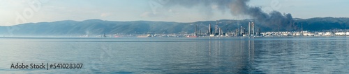 Oil refinery plant. Panoramic view of petrochemical factory and merchant ships in Gulf of Kocaeli Izmit Turkey. Factory causing environmental disaster with chemical gas. Import export concept