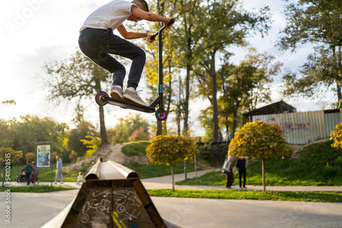 boy jumping with his scooter photo