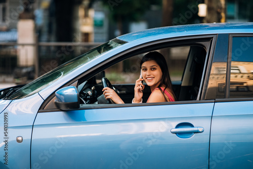 Woman sitting in car and using her smartphone.