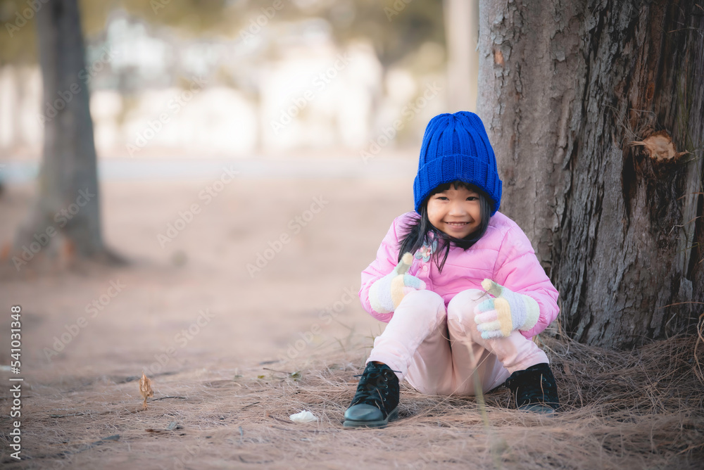 Portrait of cute asian little girl wear Winter clothes at the forest of the park,Thailand people pose for take a picture,Happy time Portrait of cute asian little girl wear Winter clothes at the forest of the park,Thailand people pose for take a picture,Happy time