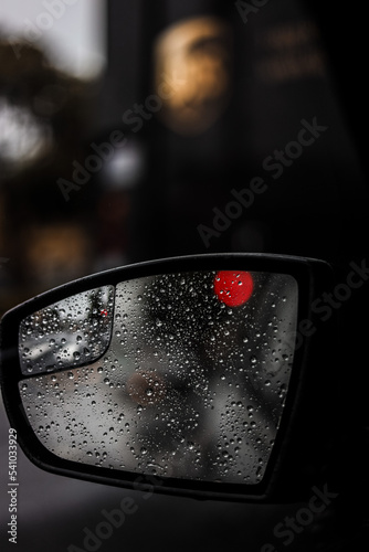 water drops on a car mirror from a rainy day 