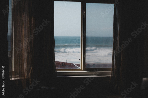Window Facing Out to a Beach with Waves Crashing in the Distance 