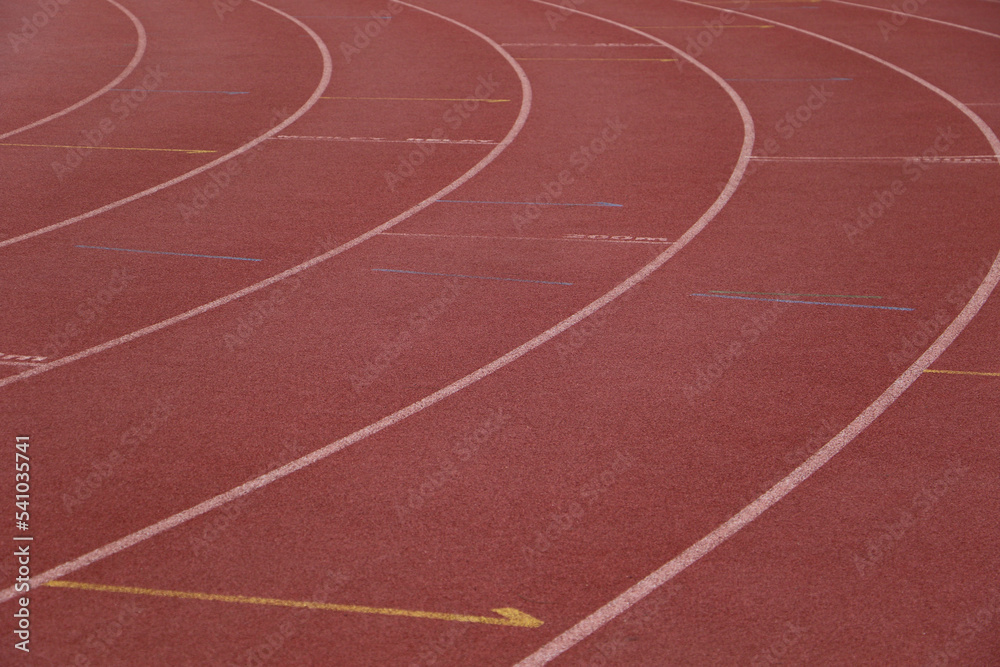 White lines forming lanes of an athletics track made of red rubber