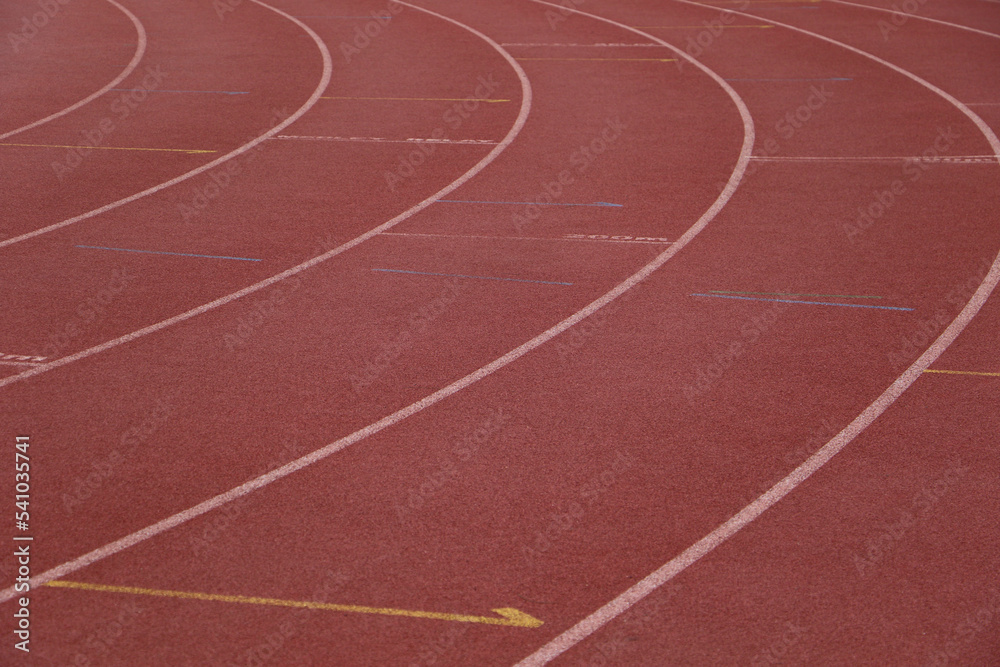 White lines forming lanes of an athletics track made of red rubber White lines forming lanes of an athletics track made of red rubber