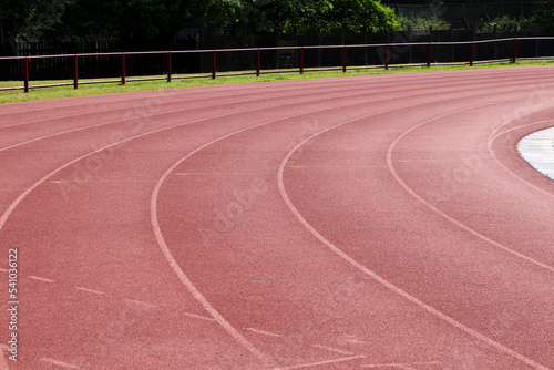 White lines forming lanes of an athletics track made of red rubber © Graham
