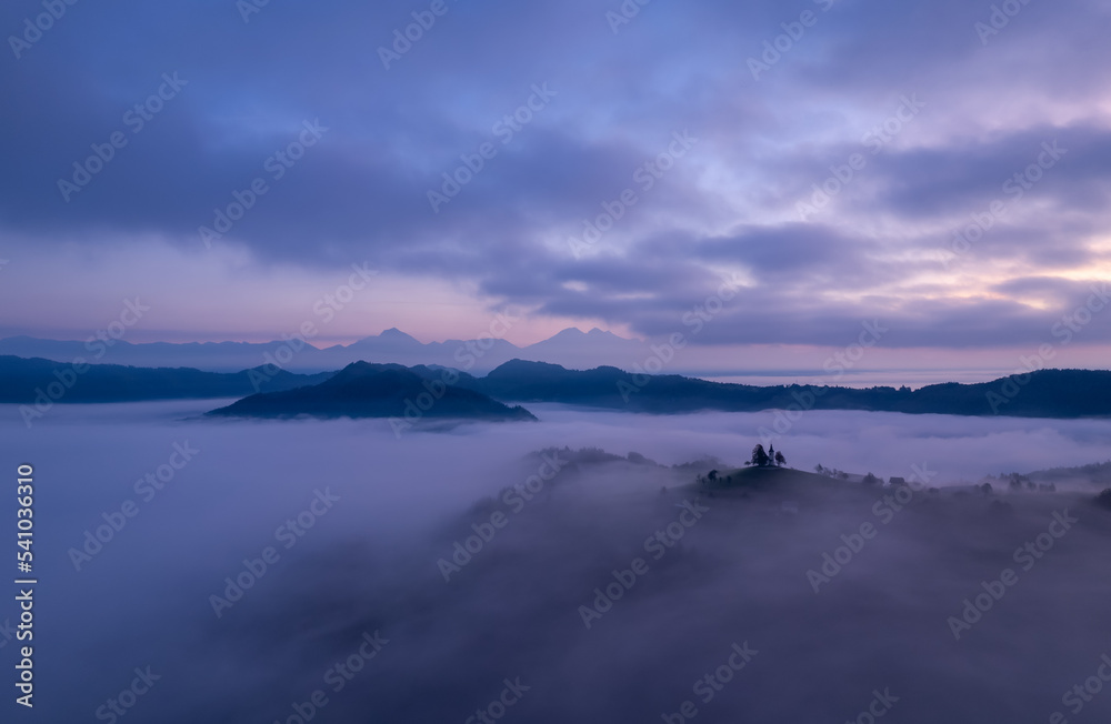 Cerkev Sveti Tomaž (St. Thomas Church) near Škofja Loka, Slovenia. Foggy morning and sunrise, drone photo Cerkev Sveti Tomaž (St. Thomas Church) near Škofja Loka, Slovenia. Foggy morning and sunrise, drone photo