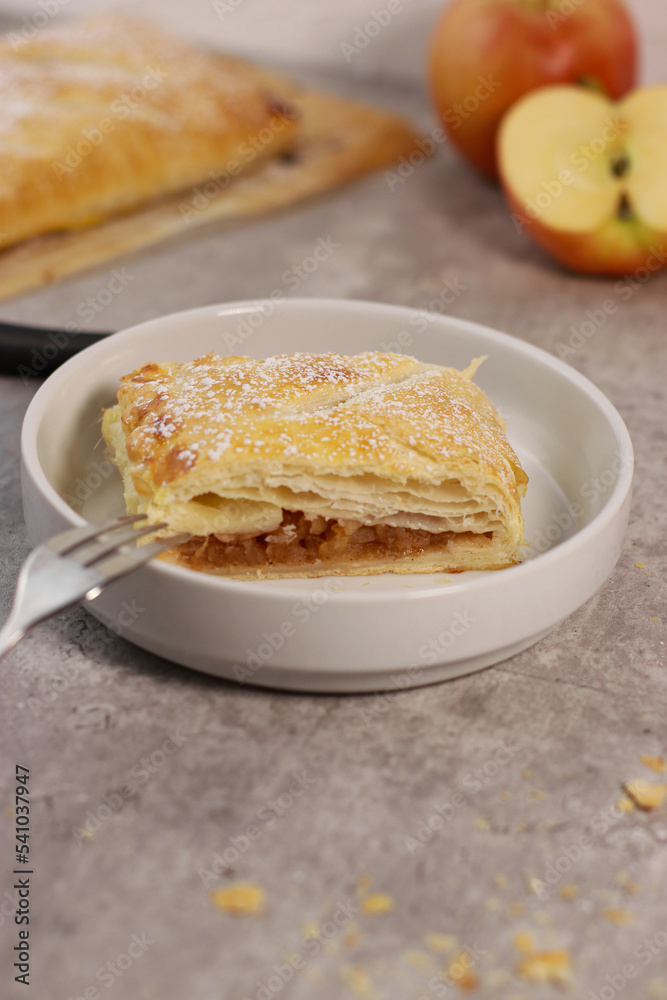 apple pastry strudel roll with cinnamon on grey marble table
