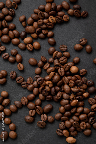 Roasted coffee beans scattered on dark background