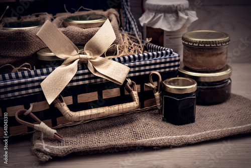 Fototapeta Naklejka Na Ścianę i Meble -  Panier cadeau rempli de bocaux et conserves gastronomiques avec ruban doré
