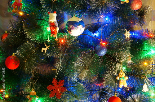 Christmas tree decorated with toys and glowing garlands.