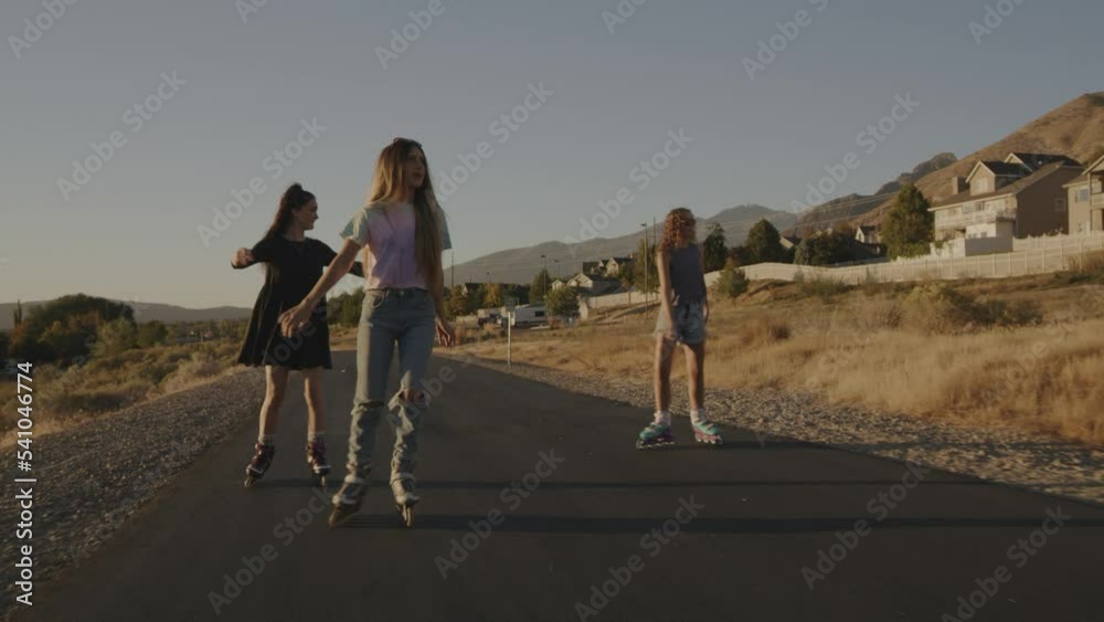 Bicyclists passing carefree girls inline skating on park path / Cedar Hills, Utah, United States Bicyclists passing carefree girls inline skating on park path / Cedar Hills, Utah, United States