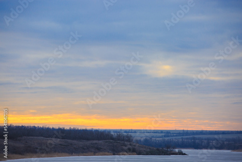 Landscape at dawn of a frozen river . Winter landscape on a frosty morning of a steppe river © MaksimM