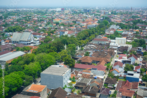 Surakarta, Indonesia - September, 2022 : A view of the densely populated residential area of ​​Solo City from the top of a skyscraper. There are many roof tiles of the house that look close together.