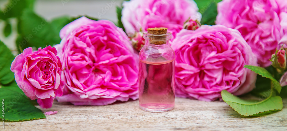 Rose essential oil in a bottle. Selective focus. Rose essential oil in a bottle. Selective focus.