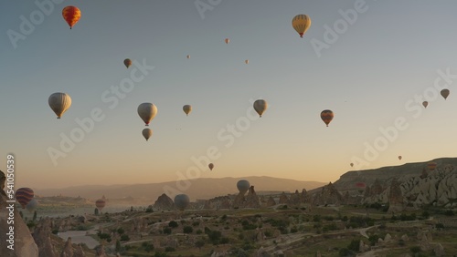 Many hot air balloons flying over Love valley early in morning in Cappadocia