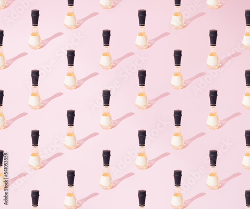 A small brandy bottle on a pink background. Pattern.