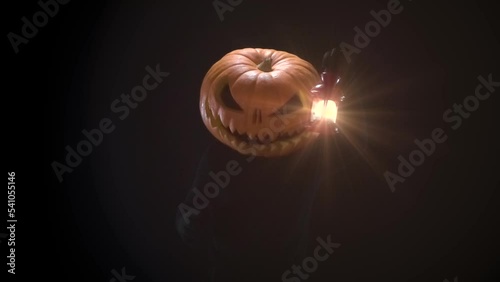 Halloween Invitation. A creature with a huge pumpkin head signals a lantern in his hand and makes invocatory beckoning gestures photo