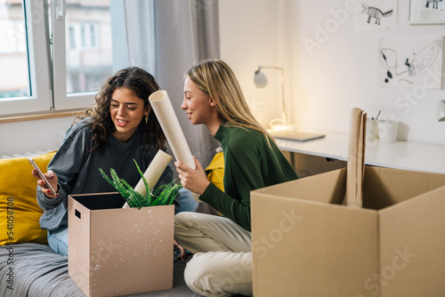 college female teenagers sits on bed and talking in room in dorm