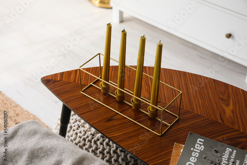 Stylish holder with candles on wooden table