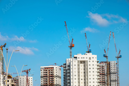 View of unfinished buildings and industrial cranes