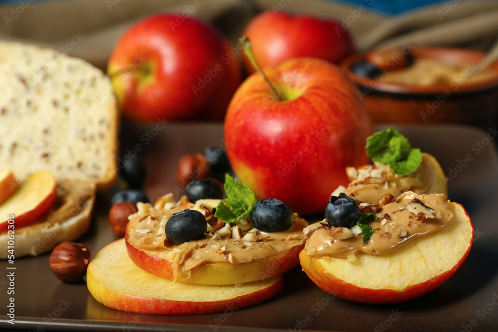 Plate of fresh apples with nut butter and blueberry, closeup
