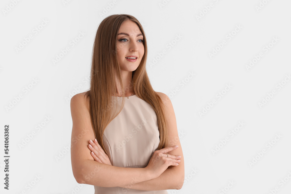 Beautiful fashionable young woman in elegant beige dress on white background Beautiful fashionable young woman in elegant beige dress on white background