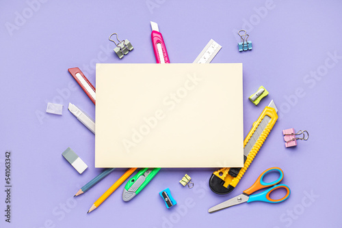 Blank paper sheet with utility knives and stationery on violet background