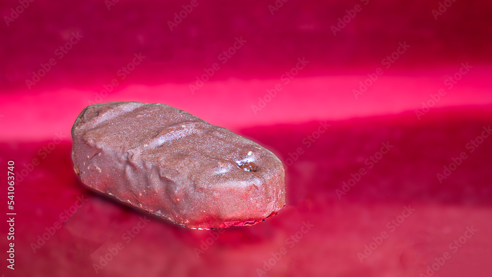 Chocolate candy on a red metallic background Chocolate candy on a red metallic background