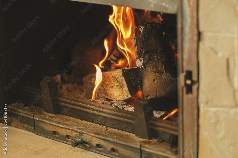 Heating house in winter with wood burning stove. Burning firewood in