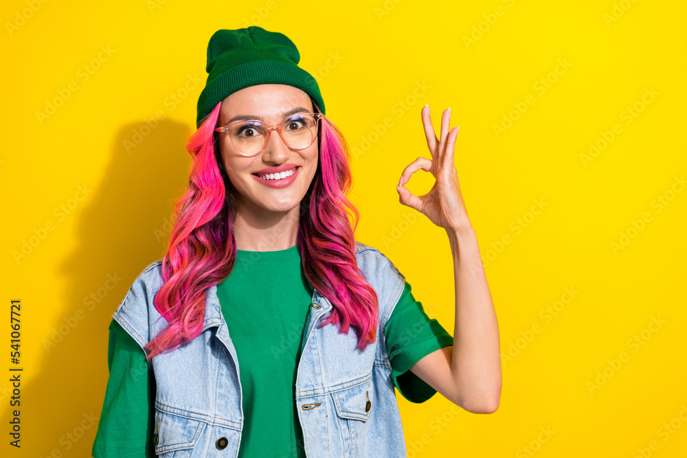 Photo of satisfied pretty lady wear green hat trendy clothes hand demonstrate okey symbol empty space isolated on yellow color background