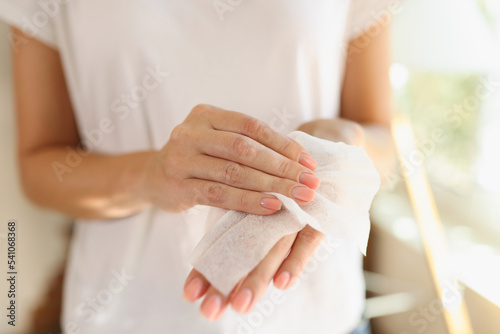 Woman cleaning hands using antibacterial wet wipes