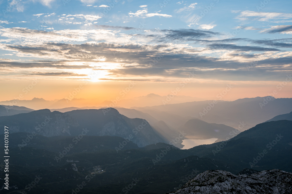 Spectacular sunrise with sun rising above lake Bled as seen from the mountains.