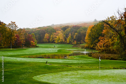 A beautiful foggy fall day on the golf course during peak foliage season.