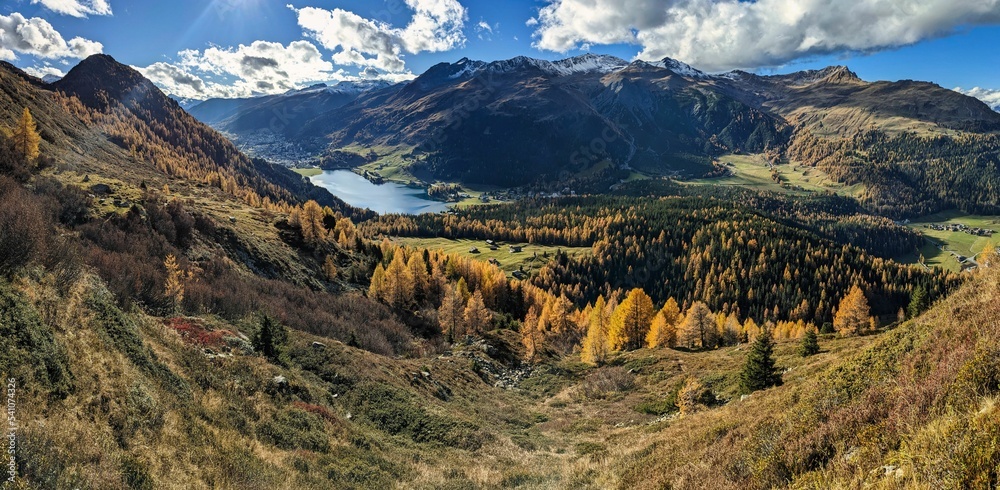Fototapeta premium beautiful autumn hike above lake davos. Colored larch forests. Mountain panorama in Davos Klosters Mountains. High quality photo