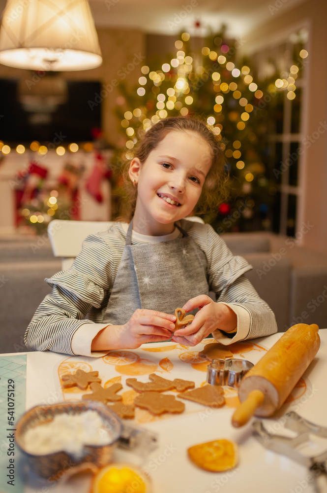 Girl preparing Christmas cookies at home in the kitchen