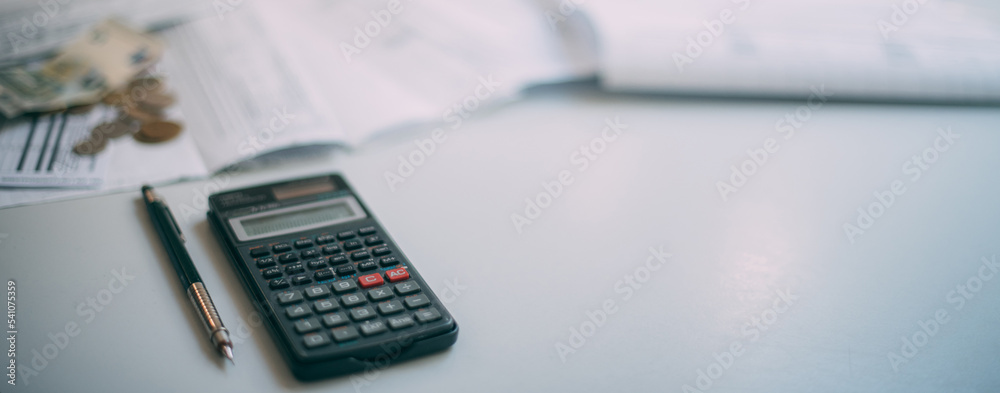 A calculator, some coins and a lot of paper utility bills on the table in close-up. No one. Place for the inscription. A calculator, some coins and a lot of paper utility bills on the table in close-up. No one. Place for the inscription.