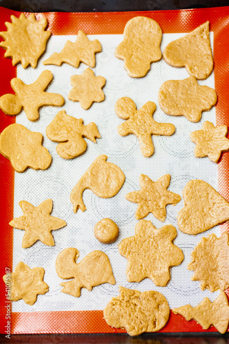 Christmas cookies in the shape of a heart, belea, a star, a tree, a gingerbread man on a baking tray photo