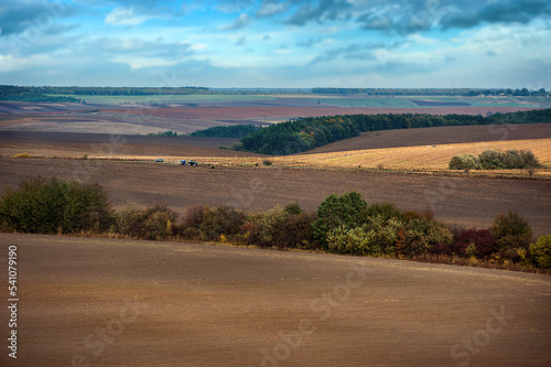 Agriculture plowed field on an autumn day. Black soil plowed field on the hil...