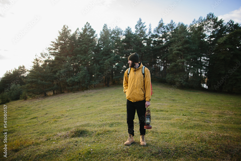 A hiker walking in nature carrying backpack A hiker walking in nature carrying backpack