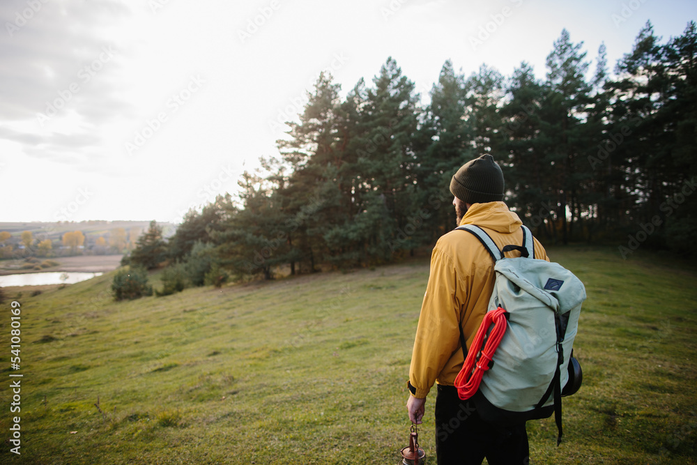 A hiker walking in nature carrying backpack