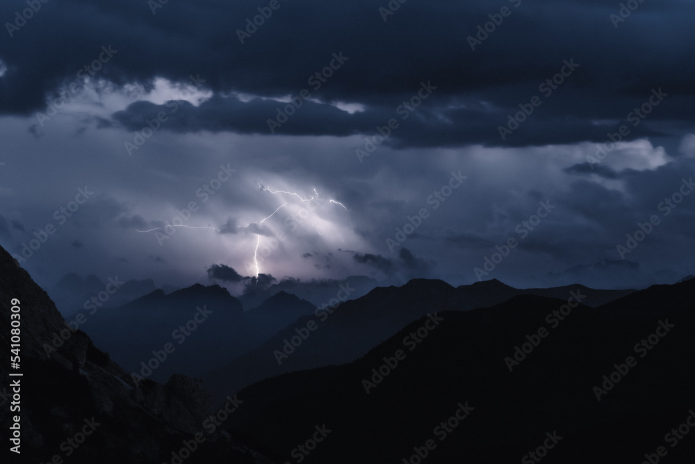 Huge lightning strike over Marmolada observed from Falzarego pass camper parking area. Falzarego pass, Dolomites, South Tirol, Italy, Europe. Huge lightning strike over Marmolada observed from Falzarego pass camper parking area. Falzarego pass, Dolomites, South Tirol, Italy, Europe.