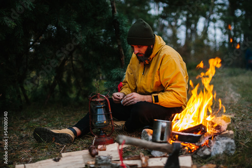 The traveler uses a kerosene lamp. Setting up a shelter in the forest for the night. © dsheremeta