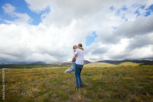 Loving young couple in white t-shirts running across the field. Happy moments in lovers lives. © Fotoproff
