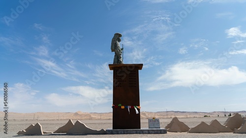 Statue of the Buddhist monk Tang Sanzang Xuanzang in Gansu, China against a blue sky photo