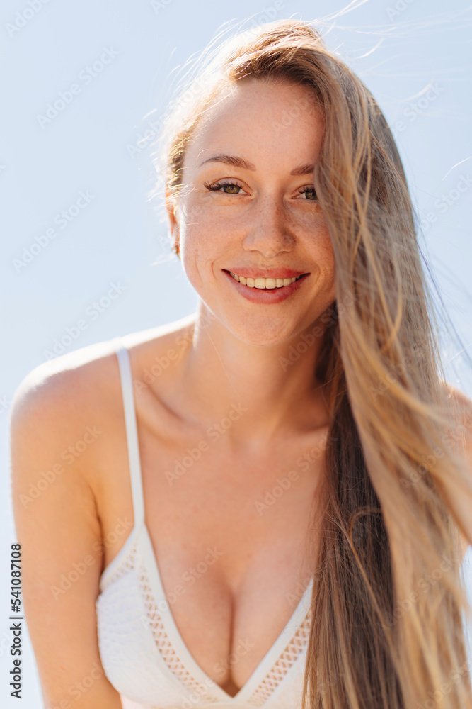 portrait of a beautiful and sexy young woman with long hair in a white swimsuit.