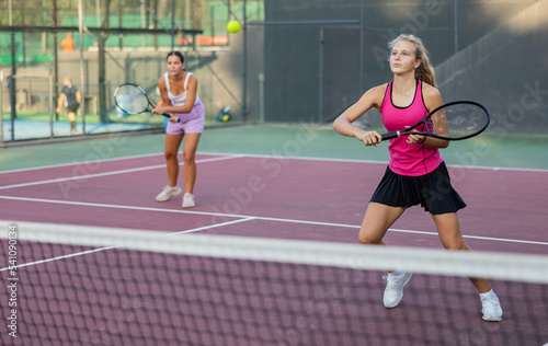 Woman tennis player training on court. Woman using racket to hit ball. © JackF